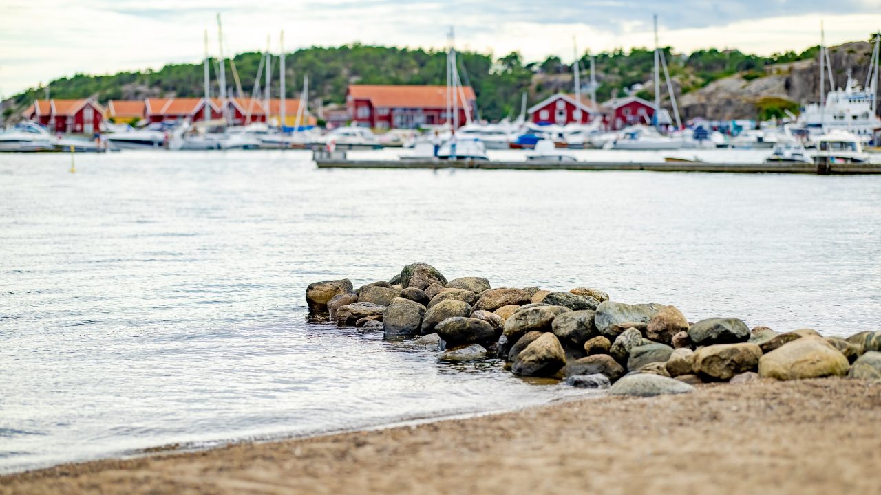 Hvaler gjestebrygge: Vi ser en steinmolo og flere seilbåter i bakgrunnen.